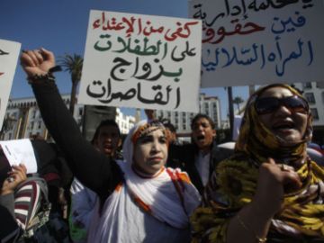 2012- Moroccan women hold signs saying, "Stop abusing girls" to protest the lack of laws against child marriage.